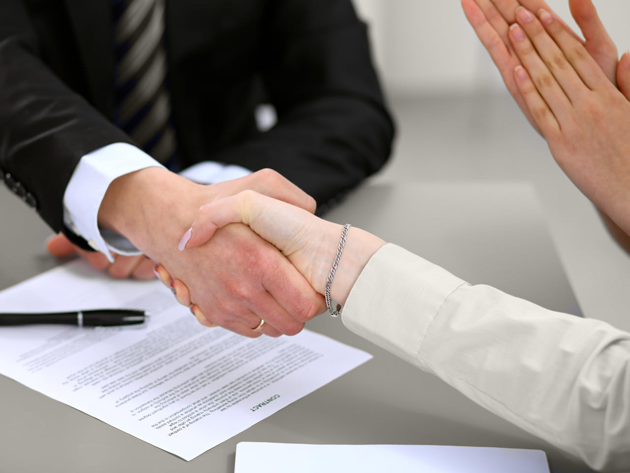 9 (Demo) people shaking hands over signed agreement